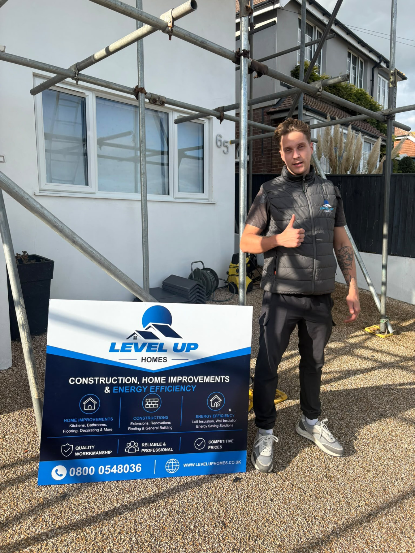 Level Up Homes team member on site beside the company sign